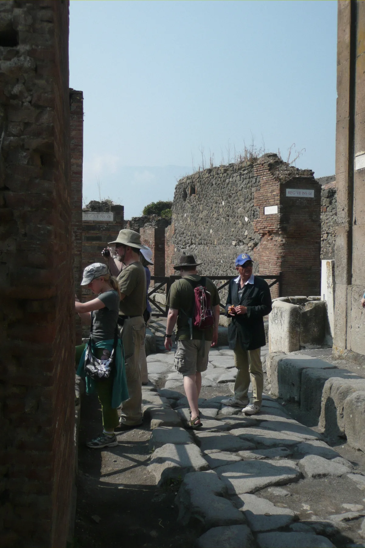 Travellers strolling the stone streets of Pompeii between tour stops